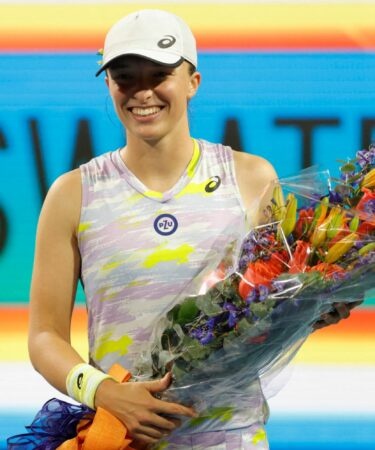 Iga Swiatek (POL) is presented a bouquet for becoming the number one women's player in the world after her victory over Victorija Golubic (SUI) (not pictured) in a second round women's singles match in the Miami Open at Hard Rock Stadium.