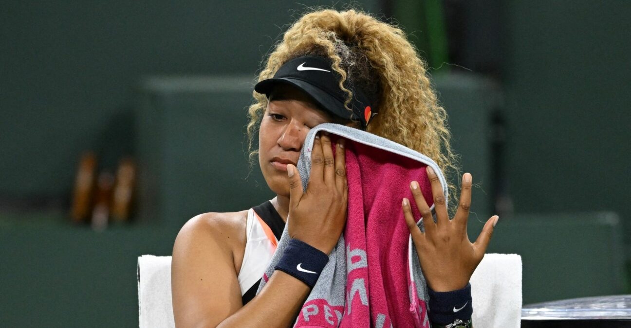 Naomi Osaka wipes her face as she talks to referee Claire Wood after a spectator disrupted play, yelling "Naomi you suck," before the start of her 2nd round match against Veronika Kudermetova at the BNP Paribas open at the Indian Wells Tennis Garden.