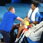 Serbia's Novak Djokovic receives medical attention after sustaining an injury during his third round match against Bulgaria's Grigor Dimitrov at the 2023 Australian Open