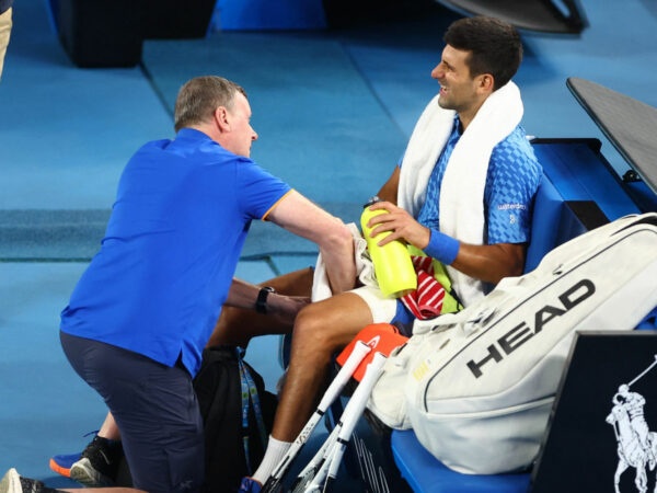Serbia's Novak Djokovic receives medical attention after sustaining an injury during his third round match against Bulgaria's Grigor Dimitrov at the 2023 Australian Open