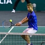 Corentin Moutet hits a backhand passing-shot against Geoffrey Blancaneaux during their match in quallies at the Rolex Paris Masters 2022