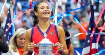 Emma Raducanu of Great Britain celebrates with the championship trophy after her match on day thirteen of the 2021 U.S. Open tennis tournament at USTA Billie Jean King National Tennis Center.