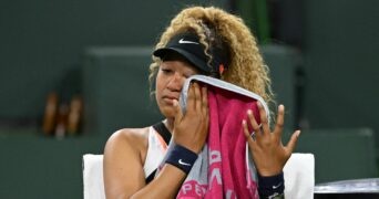 Naomi Osaka wipes her face as she talks to referee Claire Wood after a spectator disrupted play, yelling "Naomi you suck," before the start of her 2nd round match against Veronika Kudermetova at the BNP Paribas open at the Indian Wells Tennis Garden.