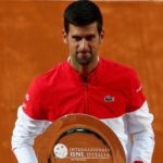 Serbia's Novak Djokovic poses with the runners up trophy after losing against Spain's Rafael Nadal in the final of the Italian Open in Rome