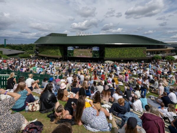 Spectators watch the men's final on a large screen as they sit on Henman Hill at the All England Lawn Tennis and Croquet Club, London, Britain