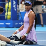 Daria Saville sits on the court as she collapses while Naomi Osaka looks on at the Toray Pan Pacific Open tennis tournament in Tokyo