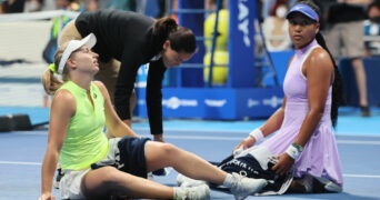 Daria Saville sits on the court as she collapses while Naomi Osaka looks on at the Toray Pan Pacific Open tennis tournament in Tokyo