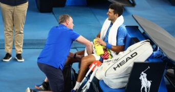 Serbia's Novak Djokovic receives medical attention after sustaining an injury during his third round match against Bulgaria's Grigor Dimitrov at the 2023 Australian Open