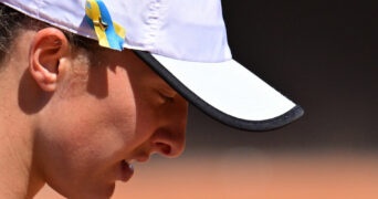 A blue and yellow ribbon in support of Ukraine amid Russia's invasion is pinned to the cap of Poland's Iga Swiatek at the 2022 Italian Open in Rome