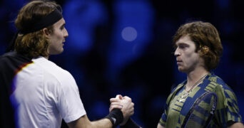 Andrey Rublev shakes hands with Stefanos Tsitsipas after winning their group stage match at the 2022 ATP Finals