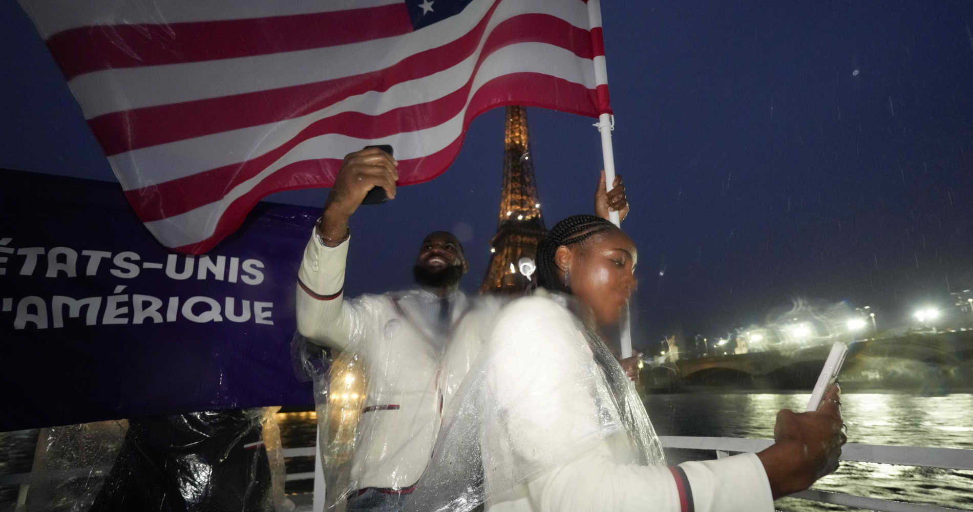 Coco Gauff and Lebron James take photos as they travel along the Seine River in Paris, France, during the opening ceremony of the 2024 Summer Olympics