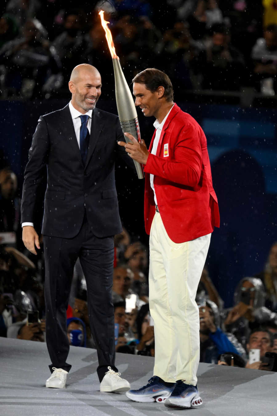 Rafael Nadal receives the Olympic torch from Zinedine Zidane during the Open ceremony of the Paris 2024 Olympic Games at Trocadero in Paris (France)