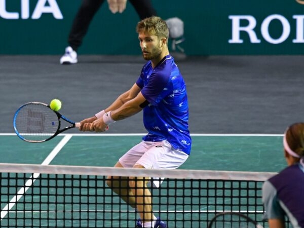 Corentin Moutet hits a backhand passing-shot against Geoffrey Blancaneaux during their match in quallies at the Rolex Paris Masters 2022