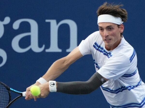 Marc-Andrea Huesler is hitting a backhand against Denis Shapovalov at the US Open 2022