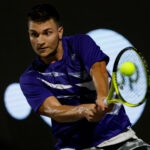 Miomir Kecmanovic is hitting a backhand during a match in Napoli in 2022