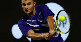 Miomir Kecmanovic is hitting a backhand during a match in Napoli in 2022