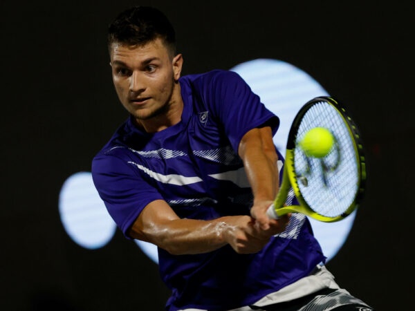 Miomir Kecmanovic is hitting a backhand during a match in Napoli in 2022